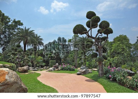 A masterpiece of landscape design - a huge and beautiful park in Thailand. Palm trees and flowers