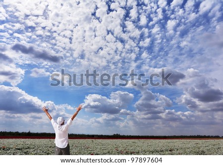 A man in a white shirt, delighted with the beauty of a cloudy sky
