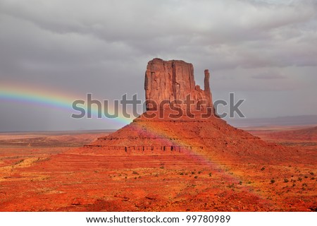 Red Desert. Monument Valley - Navajo Reservation during the summer thunderstorms. The magnificent rainbow over the famous red sandstone Mittens