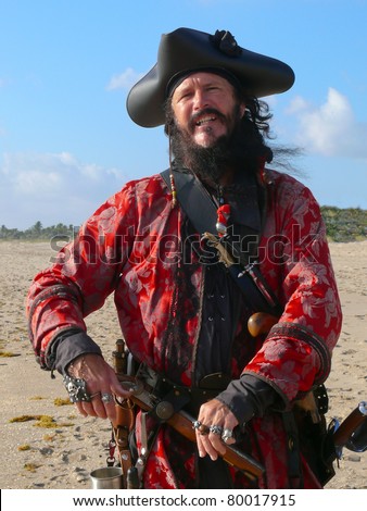 Pirate with weapons. Three quarter length portrait of a bearded man in vintage pirate costume
