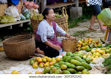 Nampan Inle Lake Myanmar 4 July 2015 Woman sells fresh vegetables and fruit on traditional asian floating market Nampan Inle Lake Myanmar 4 July 2015 Woman sells fresh vegetables and fruit on traditional asian floating market