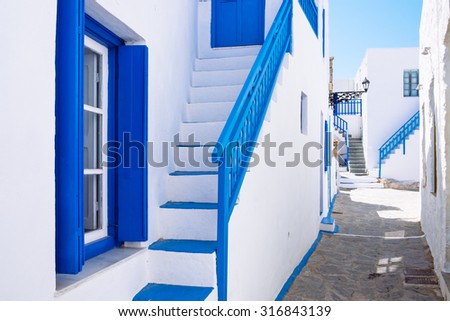 Typical traditional beautiful Greek street in white and blue style, Plaka village on Milos island, Greece