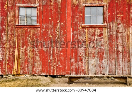 Red old barn with two windows and lonely bench, no sky and no horizon