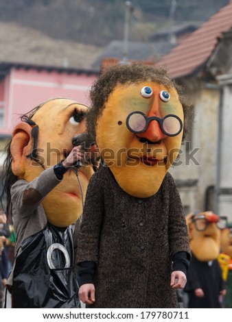 Cerknica, Slovenia - MAR 2: Traditional carnival event called Pust -  Giant head masks marching the main street March 2, 2014 in Cerknica, Slovenia