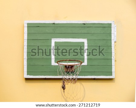 Old basketball hoop on empty outdoor court.