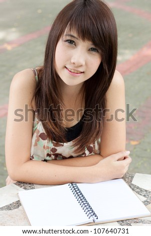 Asian girl reading a book in the park