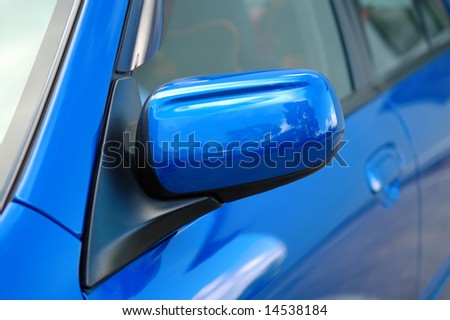 Close shot of right side mirror of shiny blue car