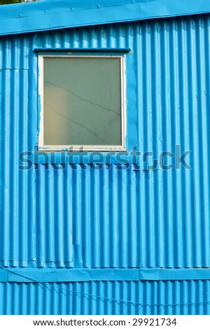 Window of blue house constructed with metal