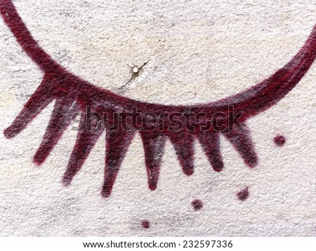 Burgundy eye drawn on old plaster wall