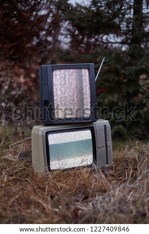 White noise and nothing on two analogue TV sets in outdoor environment