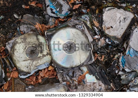 Old CD albums on the ground, optical media thrown away trash on the ground