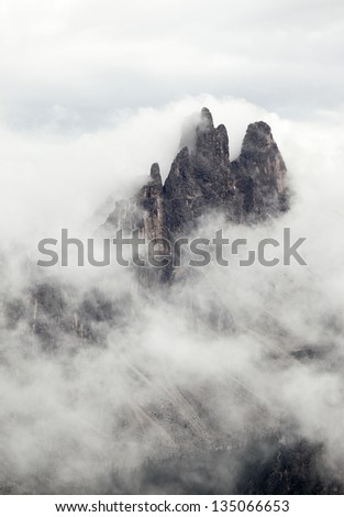 Mountain peak peeking through the clouds in the Dolomites
