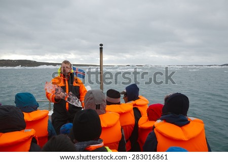 JOKULSARLON, ICELND - MAY 10, 2015: Tour guide talking about the the icebergs on an amphibian tour on the glacier lake Jokulsarlon, Iceland