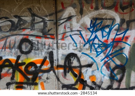 Chaotic colorful graffiti tags on a concrete wall