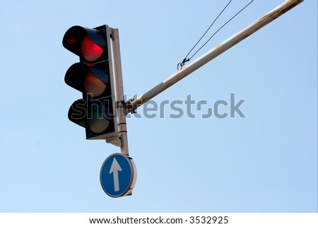 Red traffic light against clear blue sky
