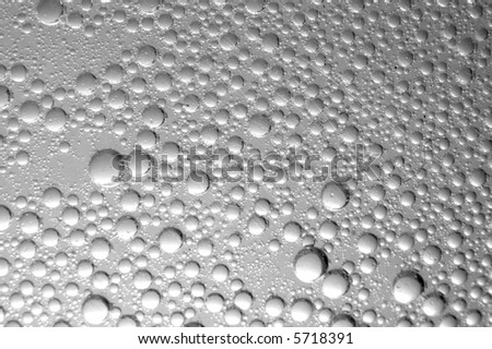 Many small bubbles on a transparent gray surface