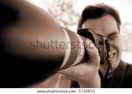 Crazy photographer using his camera with telephoto lens