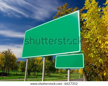 Empty green signboard at the roadside in an autumn landscape. Add your own text