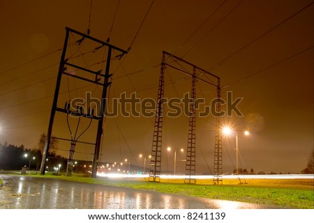 Electric pillars on a rainy night next to a highway