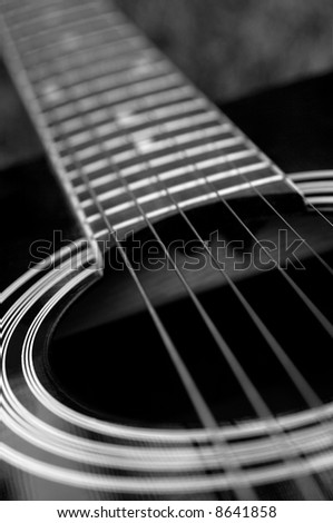 Detail of a black acoustic guitar in black and white