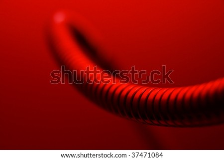 Abstract shape of a metallic tube in red light