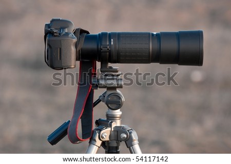 DSLR camera with telephoto lens on a tripod