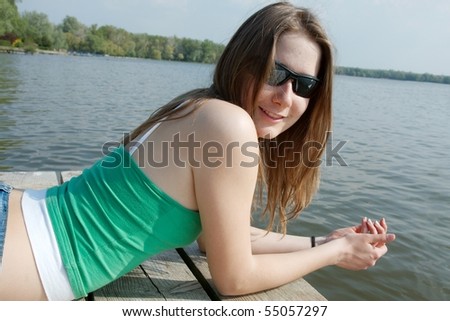 Girl laying at the lakeside in summer