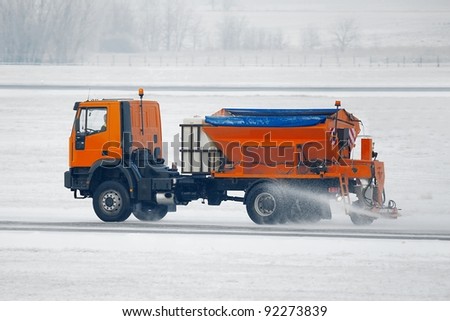 Truck deicing a road in winter