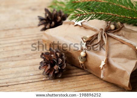 Christmas packed present with x-mas tree branches and pine cones