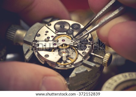 Working On A Mechanical Watch. A watch makers work top. The inside workings of a vintage mechanical watch.