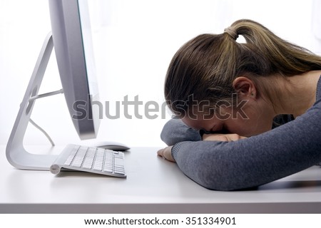 A stressed young girl sleeping in front of her computer/Stress at Workplace. Sleepy Student