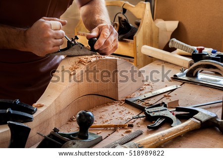 Carpenter works with a planer in a workshop for the production of vintage furniture. He makes cabriole leg for a table in the style of Louis and Queen Anne/Joiner Makes Cabriole Leg for Vintage Table