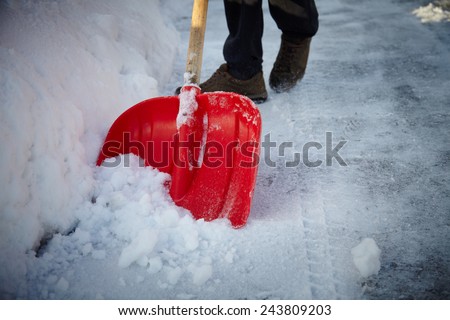Man with snow shovel cleans sidewalks in winter. Winter time. Latvia. Europe.
