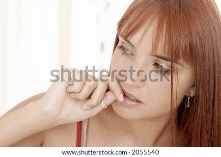 red-haired young girl, woman with  a fringe biting her nails