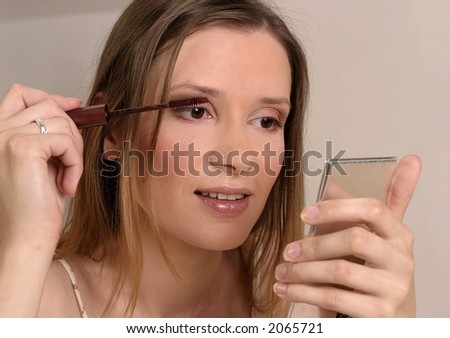 blond girl, young woman with pocket looking-glass putting make-up