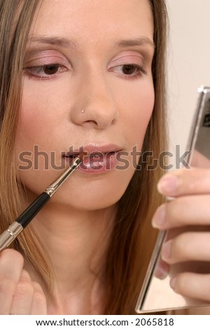 blond girl, young woman with pocket looking-glass putting make up