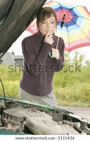 portrait of a young woman with an umbrella, standing by a broken car
