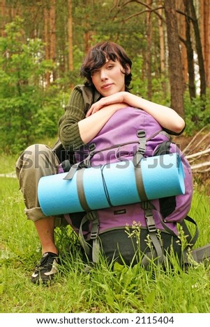 girl, young woman with a backpack hiking in a  forest-resting