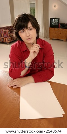 Young caucasian woman writing on paper in her room.