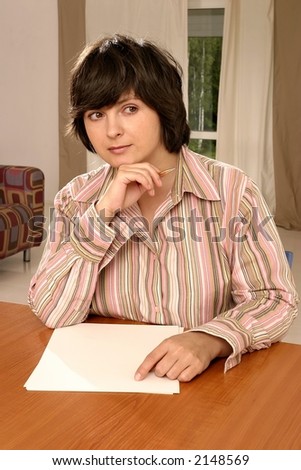 Young caucasian woman writing on paper in her room.