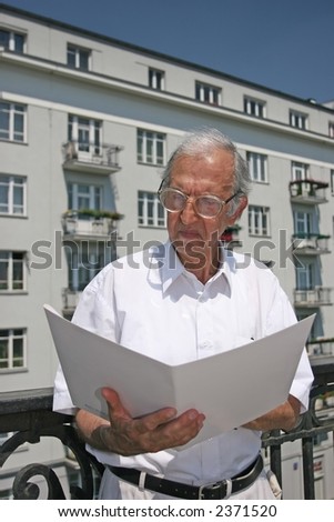 architect studying plans of house in front of appartment block