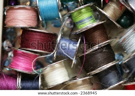 a view of colourful thread spools scattered on white surface