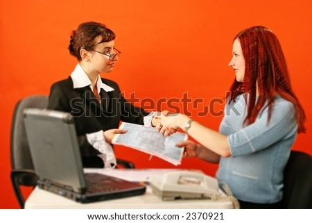two young woman shake hands in work environment