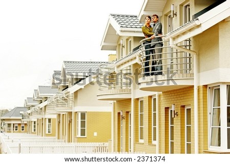 couple in front of one-family house in modern residential area