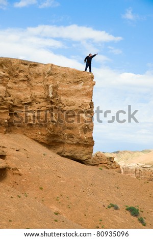 Man on a rock with the lifted hand