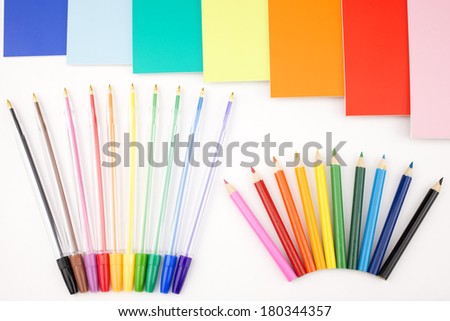 Colorful pens placed in a portrait orientation and notes on a white background
