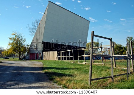 A picture of a closed drive in movie theater with weeds growing where cars once were