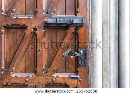 Old wooden door with wrought iron handle in the building of Old Riga