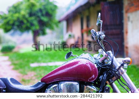 Motorcycle is the rural house with a tree in the rain