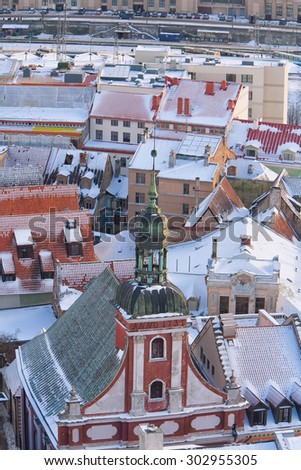 The spire of the synagogue on the background of the roofs of houses with snow in old town of Riga in winter